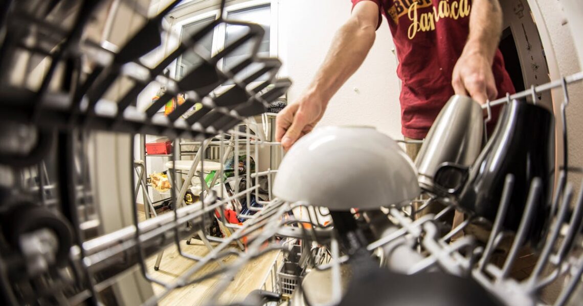 A man loading a dishwasher rack